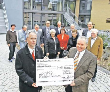 Freuen sich über eine große Spendensumme: Dirk Zeuchner (links), Geschäftsführer der Lebenshilfe Pforzheim, und Uwe Arndt, Vorstandsvorsitzender der Stiftung Lebenshilfe. Das Foto zeigt im Hintergrund ehemalige und neue Mitglieder des Stiftungsrates. (Foto: Ketterl)